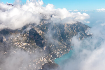 Panoramic view from Monte Comune on the coastal town Positano appearing from clouds. Magical hiking above thick fog in Lattari Mountains, Apennines, Amalfi Coast, Campania, Italy, Europe. Misty vibes