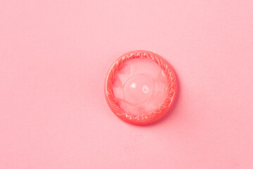 pink condom on pink background.Having safe sex
