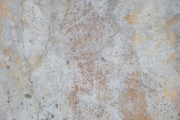 Old gray and white concrete wall with cracks and rust colored stains grunge background texture