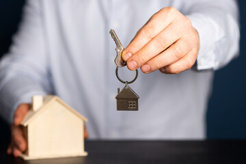 Hands with little house and key. Real estate and construction concept.