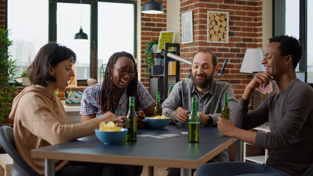 Happy group of people enjoying board strategy with cards and dice, having fun with modern competitive game at home. Men and women playing party games activity for entertainment.