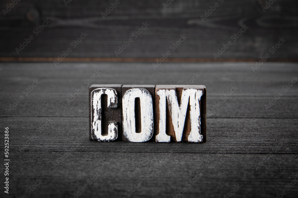 Canvas Prints com. domain name concept. word from wooden blocks on a dark background