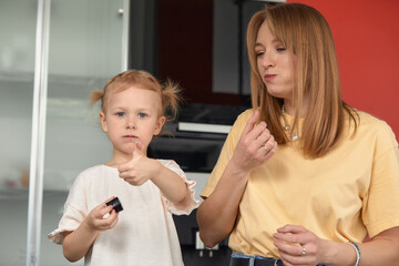 Beautiful caucasian mom and daughter eating rolls and sushi at family lunch at home. Delivery food. Traditional japanese food.