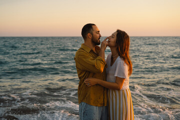 Young romantic couple dancing turning around by sea. Seascape at sunset with beautiful sky. Romantic couple on the beach at golden sunset. Lover couple having fun on beach.