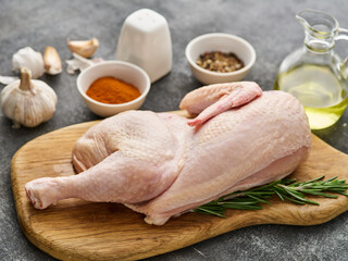 Half raw chicken, Ingredients for cooking, garlic, vegetables on wooden rustic board, uncooked chicken.