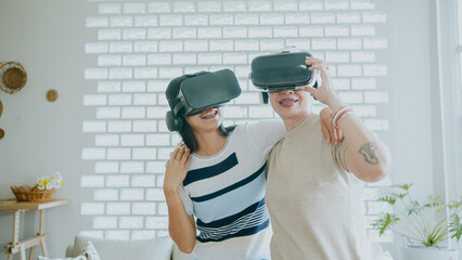 Elderly mother and daughter having fun with vr glasses.Virtual Reality make people fun and happy.Asian family Wearing VR Goggles in Leisure activities on holidays.Thai modern old man with technology.