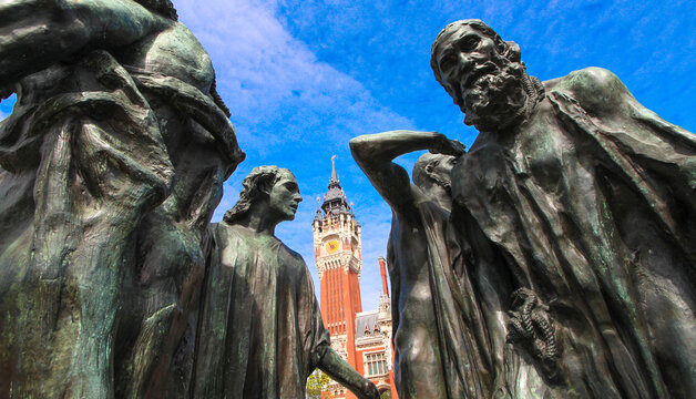 Calais, France - May 2, 2022 : "Les Bourgeois de Calais", sculpture of Rodin and Calais town hall in the north of France