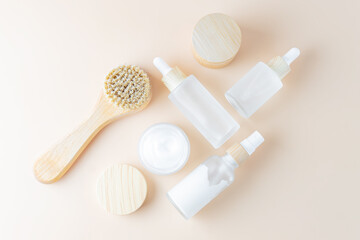 Set of unbranded skin care cosmetics with wooden face brush with natural bristle. Flat lay,...
