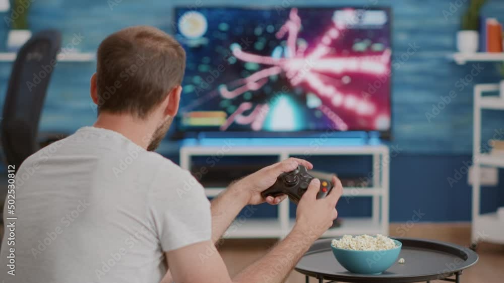 Poster closeup of man holding controller disappointed because losing online first person shooter game in fr