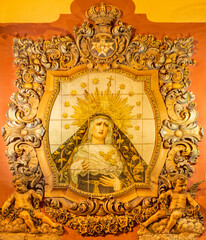 SEVILLE, SPAIN - OCTOBER 29, 2014: The ceramic tiled, cried Madonna on the facade of church Iglesia...