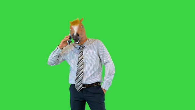 Angry businessman in horse mask has misunderstanding talking on phone call speak counting to three on a Green Screen, Chroma Key.