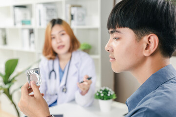 Healthcare and safe sex concept concept, Teenager boy meeting with doctor about condom use in clinic.