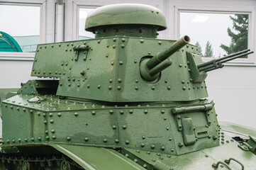The tower of an old tank with a gun. Old armored vehicles. Tracked tank with riveted hull and turret. A rare instance of a tank.