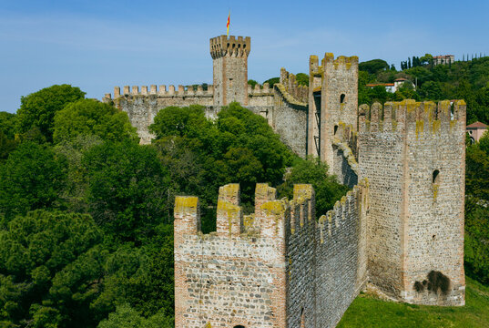 Medieval walls and towers surrounded by greenery with a blue sky background. Carrarese Castle, Este, Italy. Aerial view.