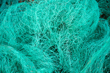Turquoise green fishing net background. Waste in nature. Environmental protect.  - obrazy, fototapety, plakaty