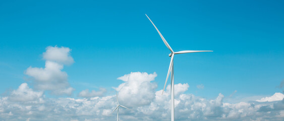 Panoramic photo of a windmill with high wind turbines for generation electricity against the blue...