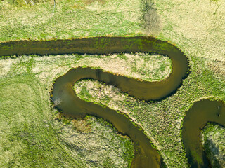 Aerial view of river valley in beautiful spring light, Czech republic, Europe. Meanders of Ploucnice river. River twists like a snake. Swirling river