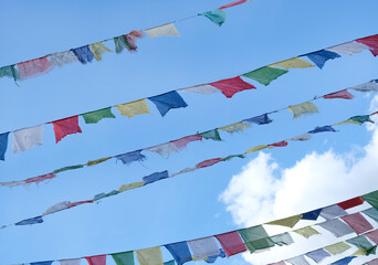 Tibetan prayer flags flying in the wind on a sunny day