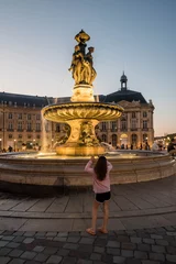 Fotobehang young girl photographing the Fountain of the Three Graces on the Place de la Bourse in Bordeaux © Image'in