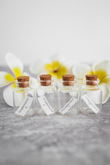 natural beauty and organic ingredients in skincare, small bottles of ingredients with flowers in the backgroun