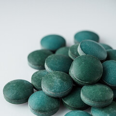 green spirulina dried seaweed on a white acrylic background