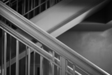 Minimalist view of stairs and handrails in black and white.