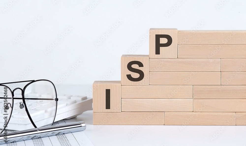 Poster wooden cubes with letters isp internet service provider on the white table with keyboard and glasses