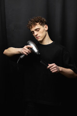 handsome barber bw portrait studio. Hair dryer and comb in barber's hands