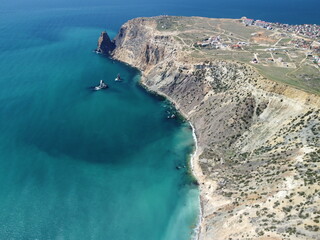 Aerial view on calm azure sea and volcanic rocky shores. Small waves on water surface in motion blur. Nature summer ocean sea beach background. Nobody. Holiday, vacation and travel concept