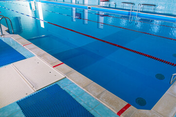 Swimming pool with clear blue water. Swimming paths in the pool. Swimming pool for water sports. Water in the pool.