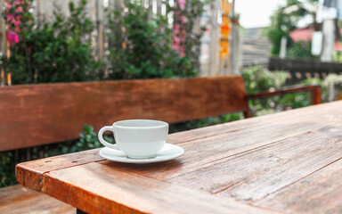 cup of coffee on wooden table in morning sun