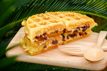 Delicious waffles on the wooden plate at garden.