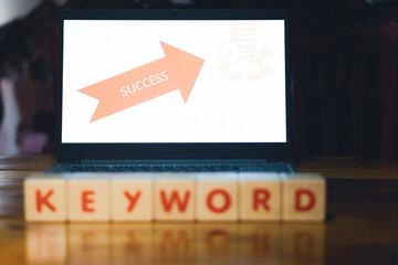 Keyword signed on a wooden cube in front of a laptop, research new ideas, finding solutions, unlocked the issue, business grow success the target, wooden Cube concept.