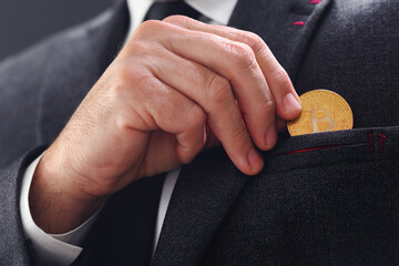 Businessman pulling Bitcoin out of his pocket