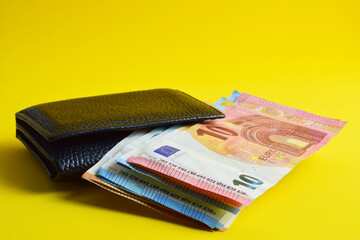 Wallet with euro, yellow background.