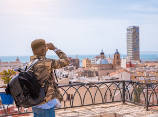 Viajero mirando la ciudad en un d&iacute;a soleado. Foto horizontal, con espacio para texto.