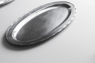 An empty silver tray is on white tablecloth