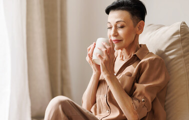 Mature woman enjoying hot drink in morning