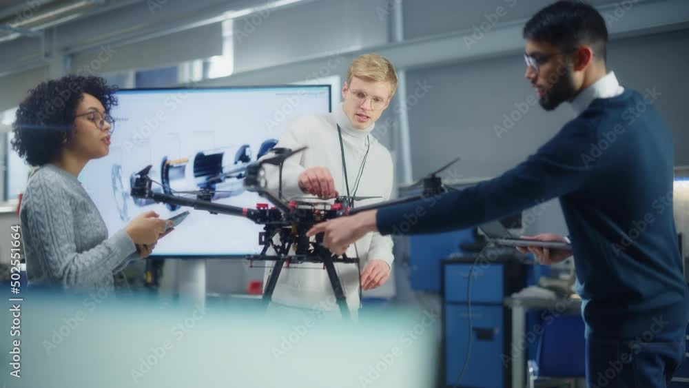 Poster Diverse Engineers Brainstorming while Use Laptop. Caucasian Male Sets Up Drone. Colleagues Building, Configuring and Testing Drones. Progressive Technologies Concept