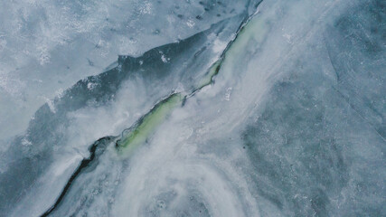 Obraz na płótnie Canvas Cracks in a frozen lake from above