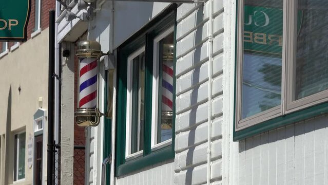 Barber pole turning on front of barber shop building.