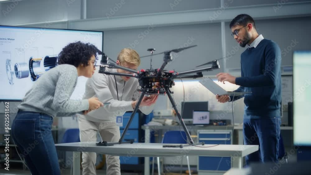 Poster Caucasian Young Engineer Examining Drone with Diverse Colleagues In Development Laboratory. Research into the Design, Operation and Performance of Drone Mechanism Concept