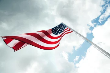 Foto op Canvas USA America flag waving in the wind over cloudy sky low angle view. © greola84