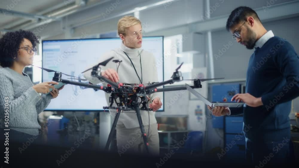 Poster Black Male Engineer Coding at Laptop while Programming Drone with his Colleagues In Factory. Research into the Design, Operation and Performance of Drone Mechanism Concept