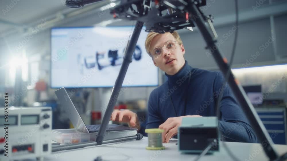 Aufkleber young caucasian male engineer put processor at the drone and type at laptop while designing unmanned