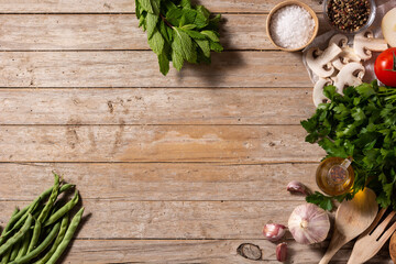 Assortment of vegetables, herbs and spices on wooden table. Top view. Copy space