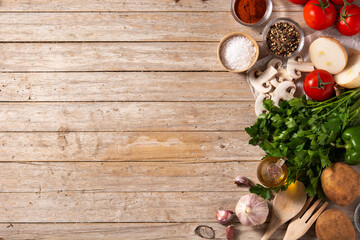 Obraz na płótnie Canvas Assortment of vegetables, herbs and spices on wooden table. Top view. Copy space