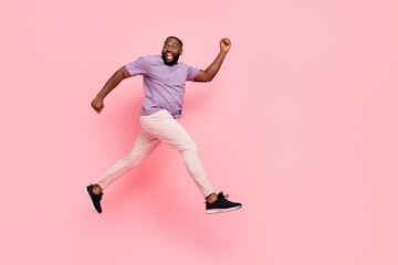 Fototapeta na wymiar Full length body size view of attractive cheerful guy jumping running flight isolated over pink pastel color background