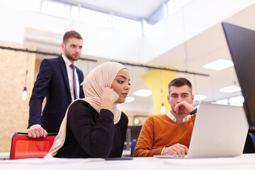 Multiethnic colleagues working on computer in a modern cowokring office space. Diversity and success concept.