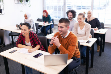 Multi ethnic students listening to a lecturer in a classroom. Smart young people study at a college.